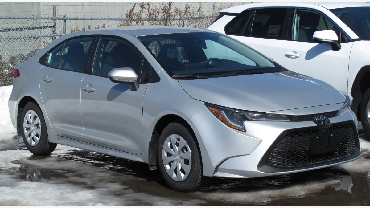 DrivingBench fitted a Toyota Corolla with a comma four device so frontier models could steer, accelerate, and brake through a parking-lot cone course.
