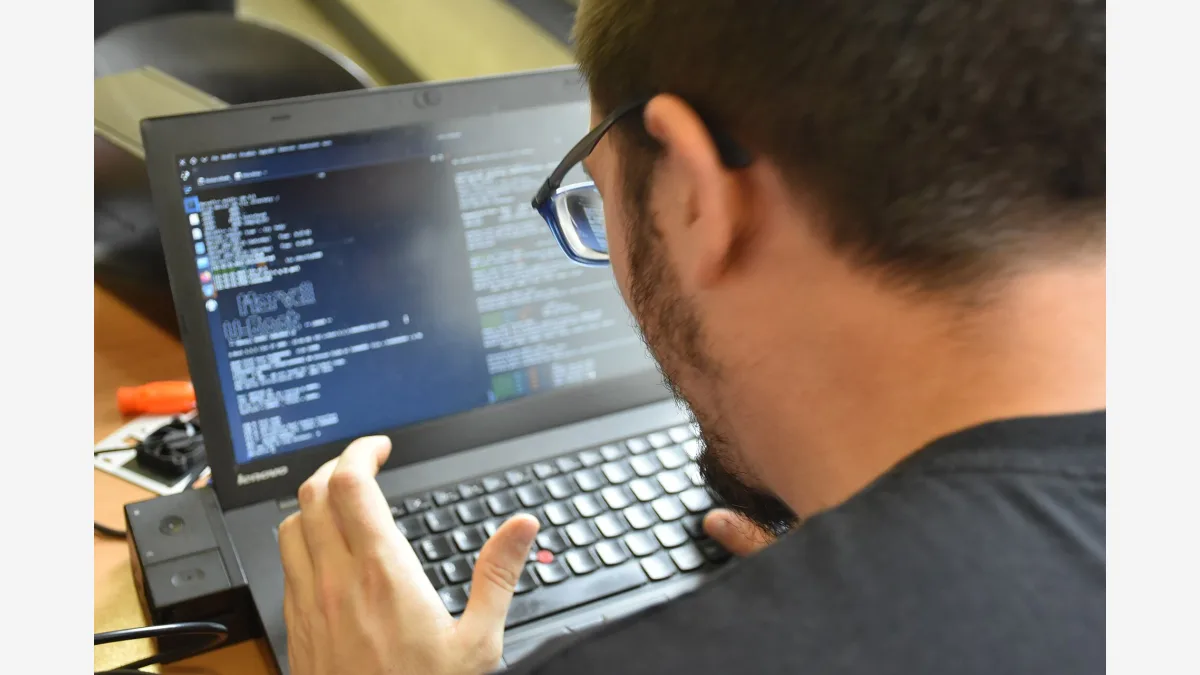 A developer working at a Linux laptop; CLOSEDQUORUM is a Go-compiled Windows implant that routes its attack decisions through commercial LLM APIs rather than an attacker-run server.