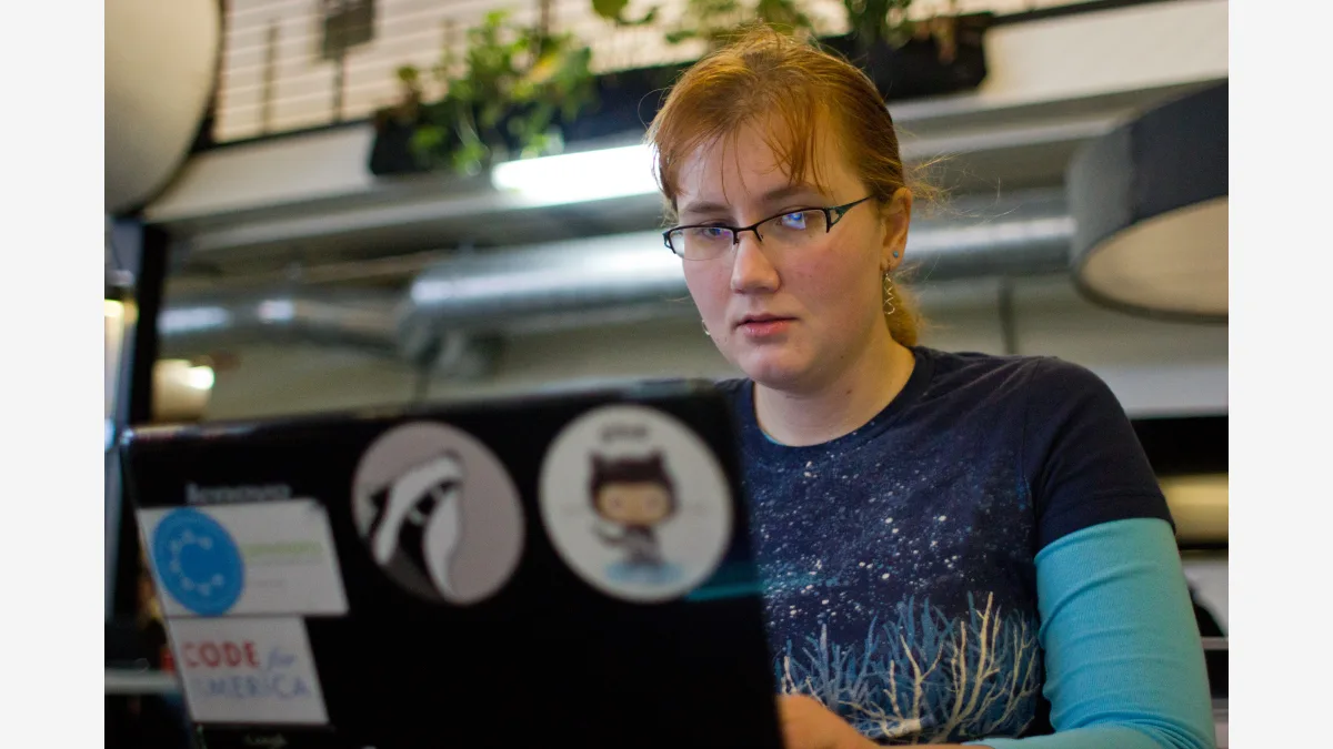 Developers collaborating at a San Francisco hackathon — Zed's Delta moves code review into shared threads that agents and teammates join together.