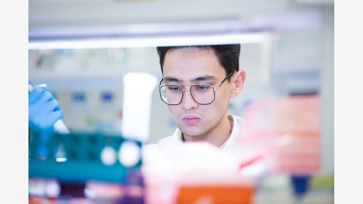 Precision pipetting at a research bench — the kind of physical experimental work Anthropic has now brought in-house at its Bay Area wet lab.