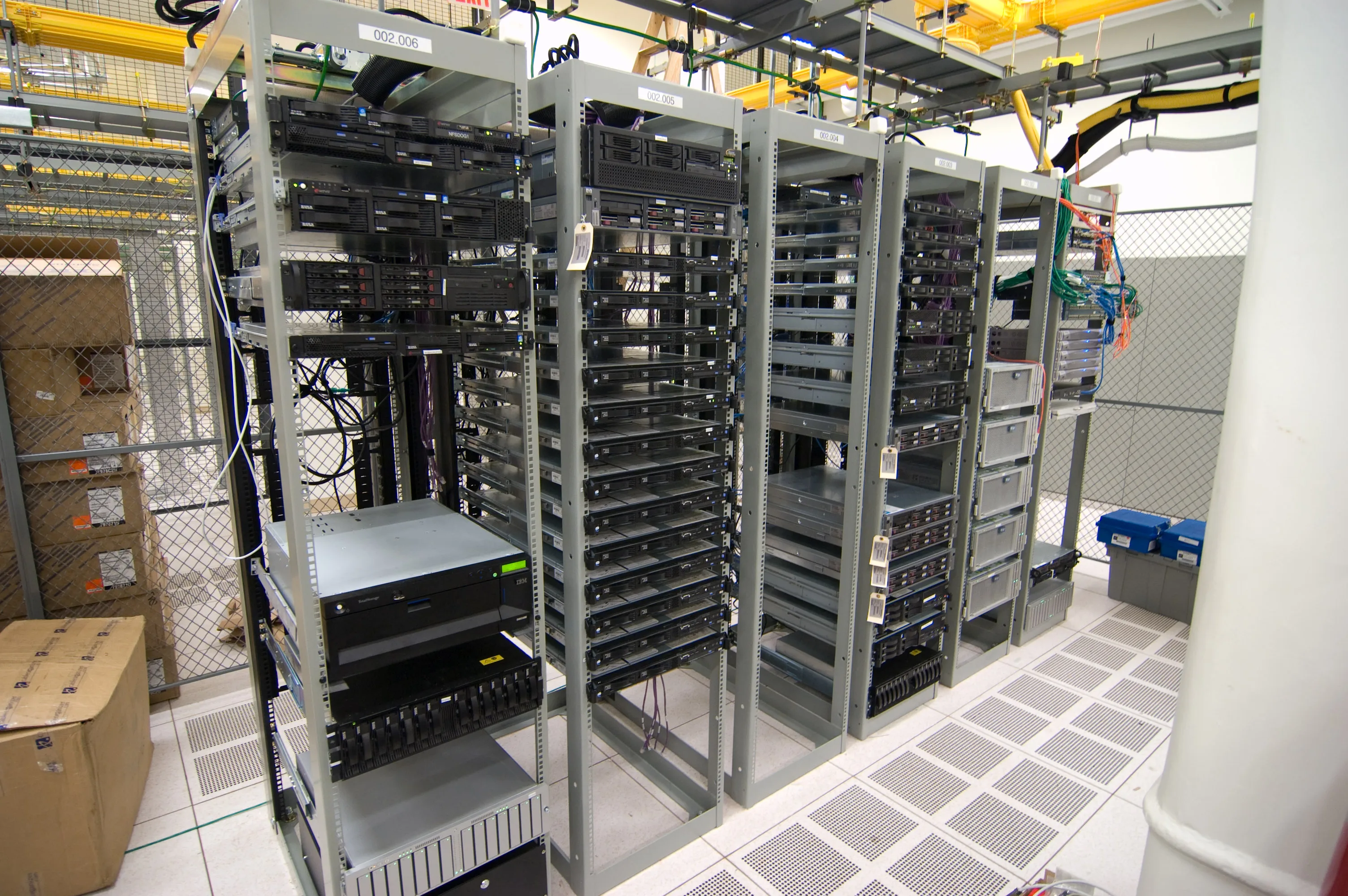 Server racks in a data center - Baseten runs AI inference infrastructure, where a stale build credential granted admin rights on the repositories driving its clusters